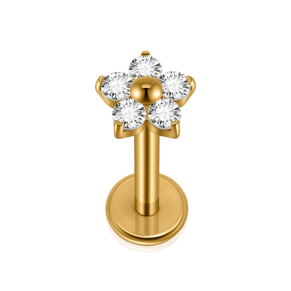 Gold lip ring with flower-shaped crystal design on a white background